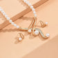 Gold necklace with pearls on a peach background