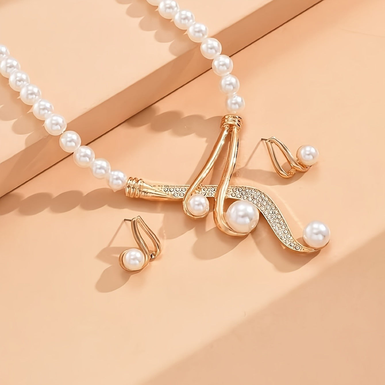 Gold necklace with pearls on a peach background
