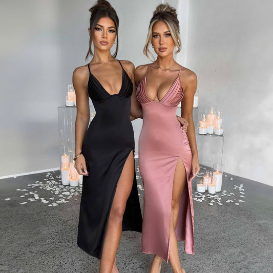 Two women in black and pink dresses standing in a decorated room with candles.